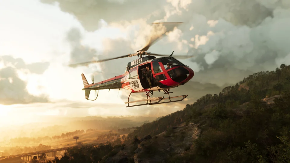 Red-and-white helicopter over a wooded ridge